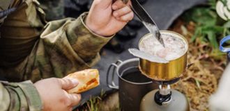 rangers team are heated food on the fire and eat in the forest
